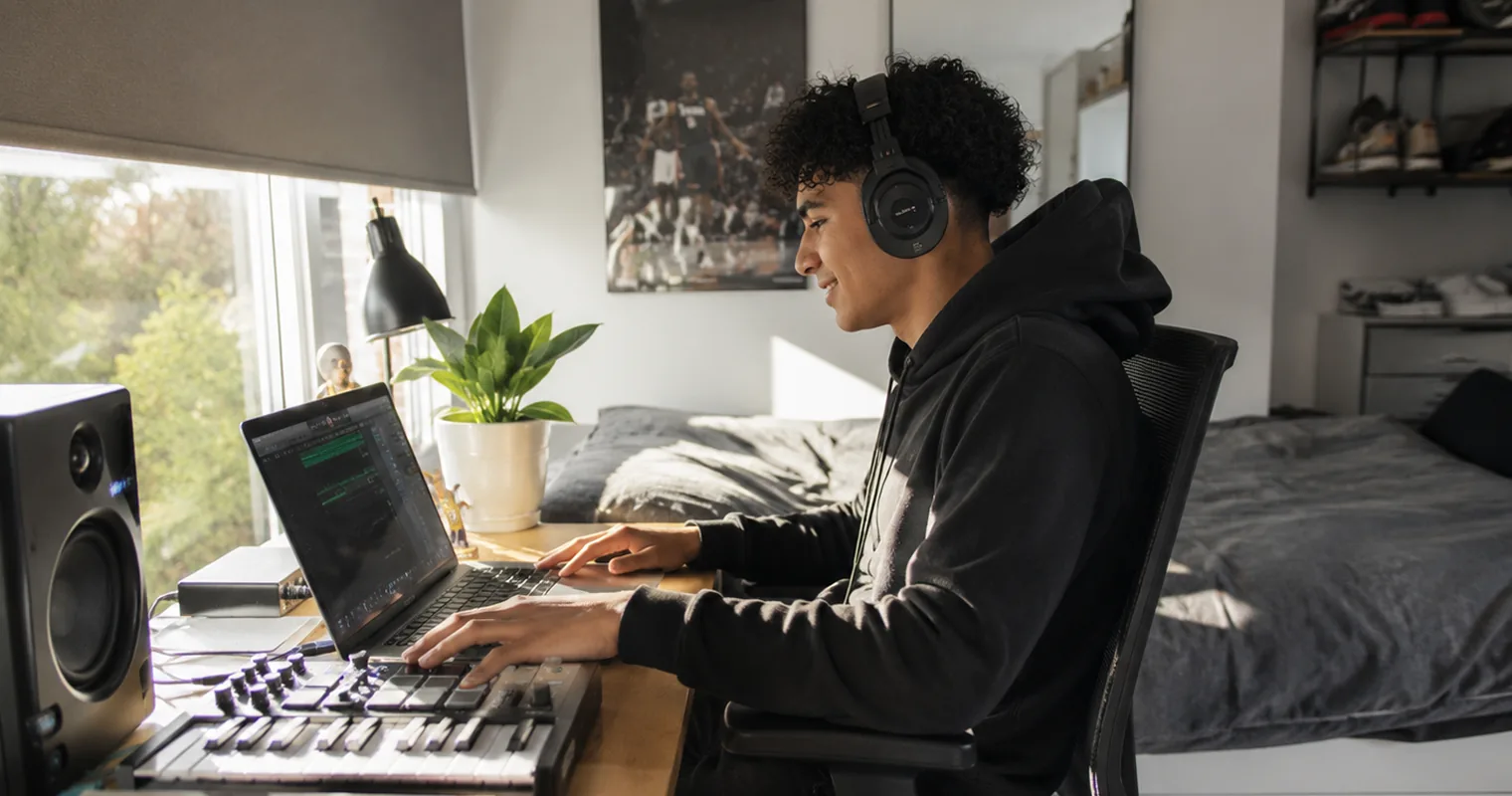 Jongen werkt met laptop en muziekapparatuur dankzij stroom uit de thuisbatterij
